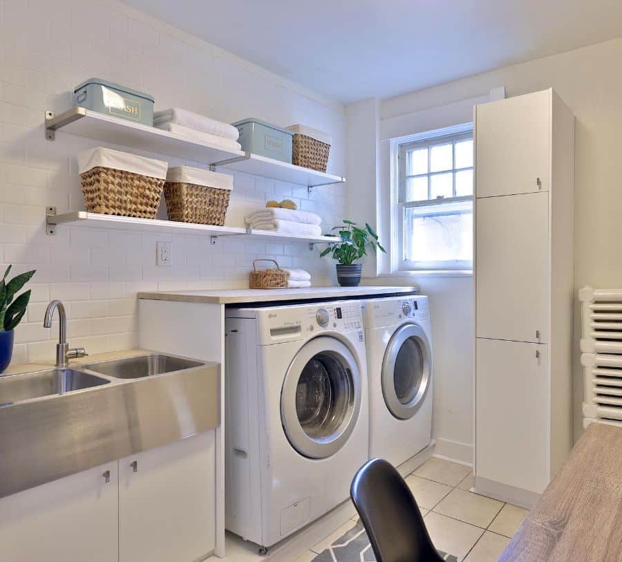 white brick laundry with stainless steel sink and washer and dryer