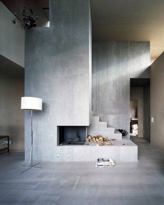 Modern concrete fireplace integrated with stairs, creating a unique architectural centerpiece for contemporary living spaces.