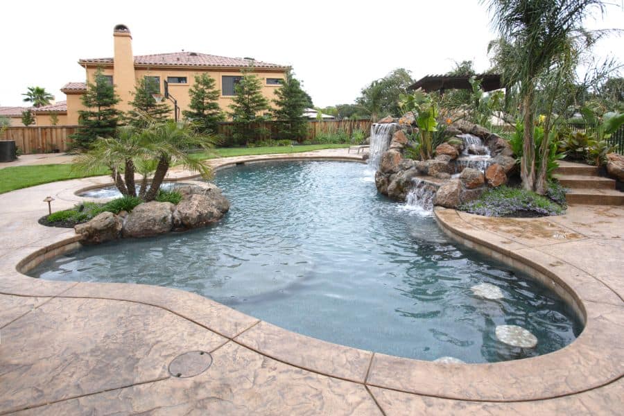 stamped concrete pool deck with waterfall