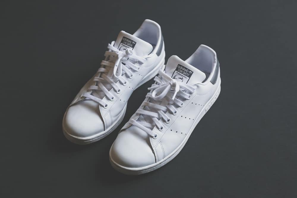 white stan smith shoes on black background