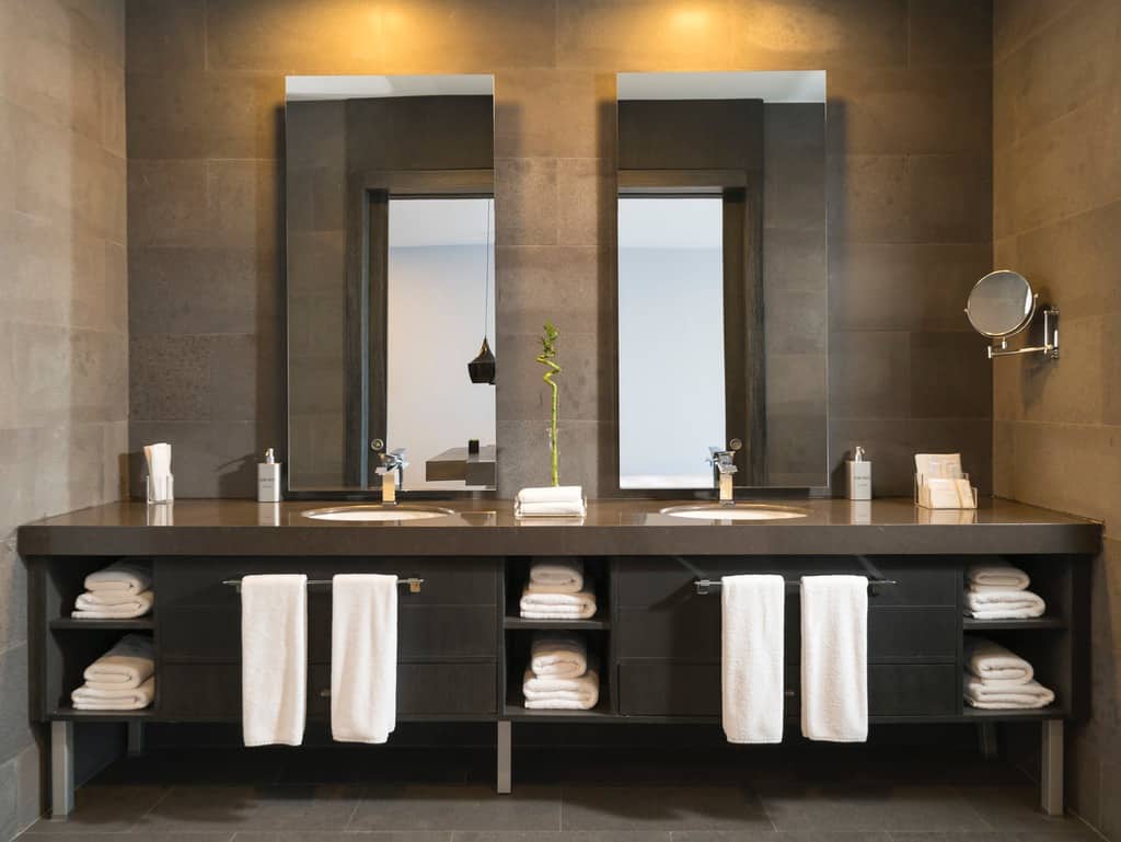 Large double vanity with dark cabinets and mirrors, featuring towel storage underneath.