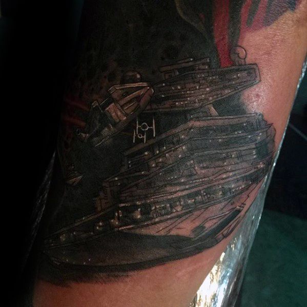 Dark-toned Star Destroyer tattoo with layered detailing and a small TIE fighter, creating a dramatic galactic battle scene.