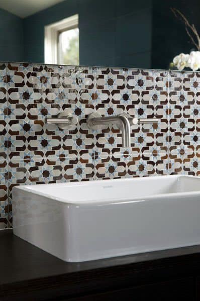 Bathroom with colorful patterned tile backsplash, wall-mounted faucet, and white rectangular sink.