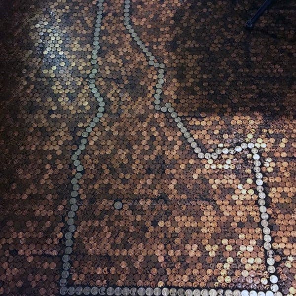 Penny tile floor featuring a state outline design bordered with nickels for a unique look.