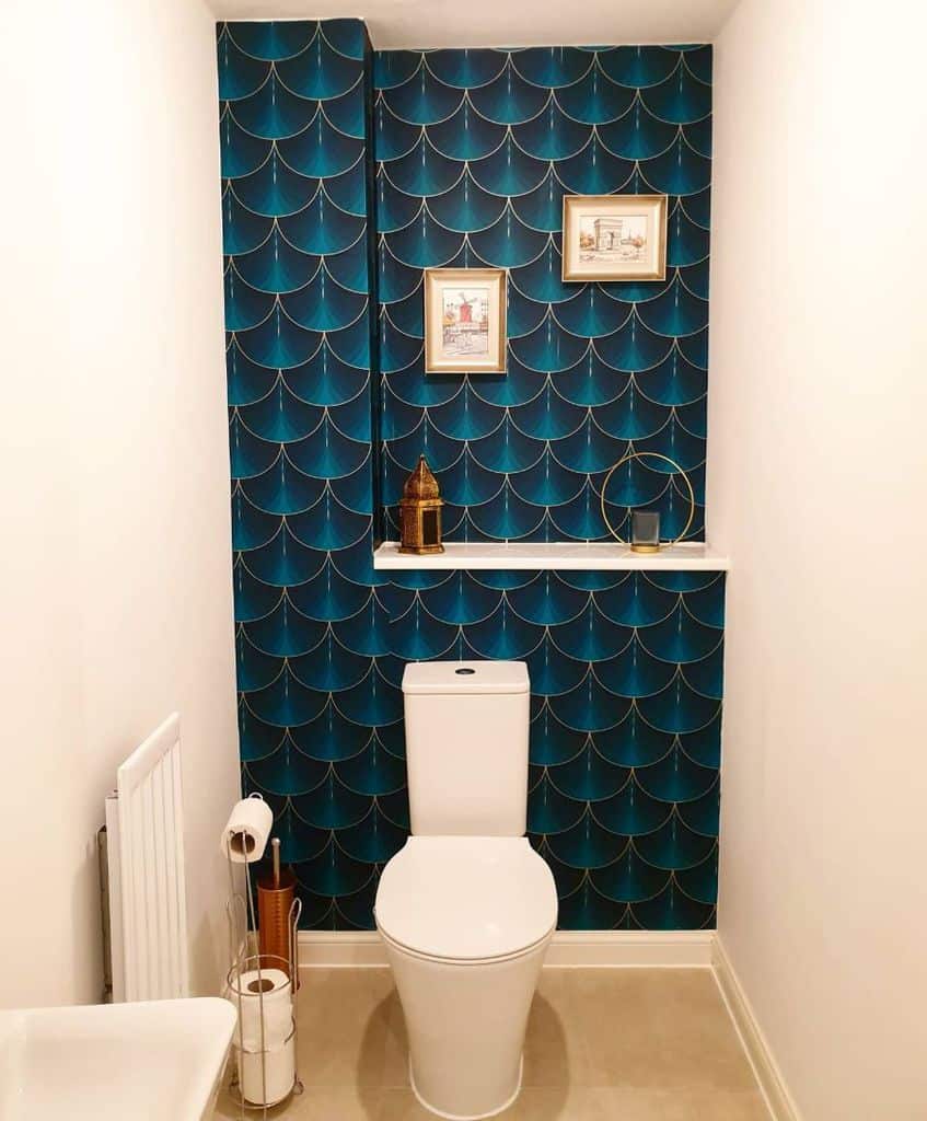 Small bathroom with bold blue patterned statement wall and minimal decor.