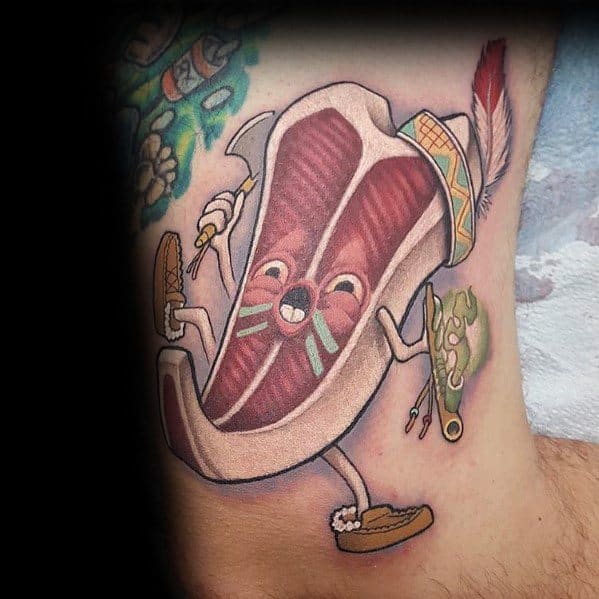 Tattoo of an anthropomorphic steak character with a playful face, tribal-inspired details, and accessories, creating a fun and unique design.