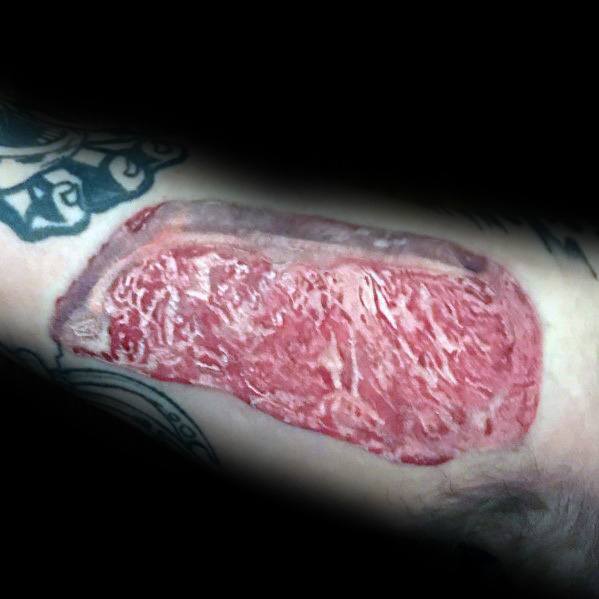 Tattoo of a highly detailed and realistic marbled steak, featuring intricate shading and texture for a bold and lifelike meat-inspired design.