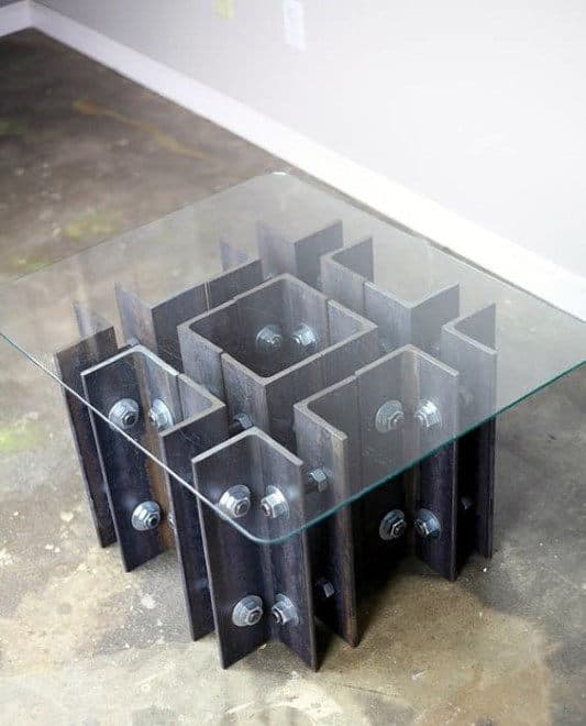 Glass-top coffee table with a geometric metal base featuring hexagonal bolt details