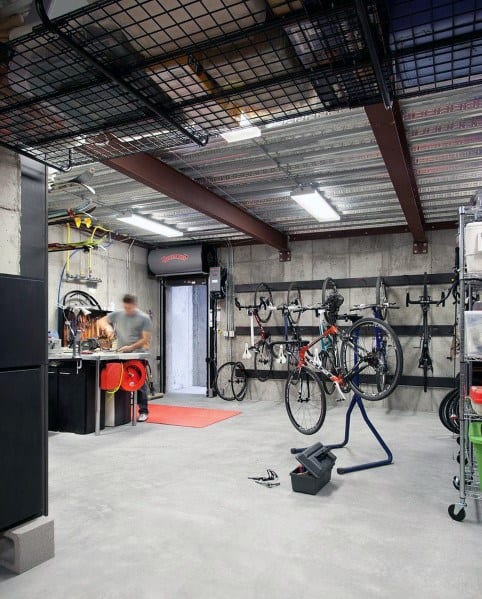 Garage with metal ceiling, steel beams, bike storage racks, and a compact workshop area.