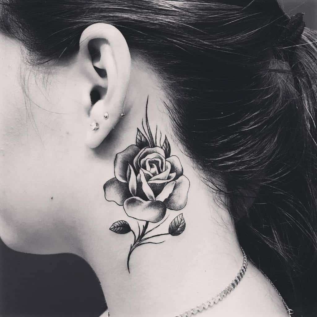 A black rose tattoo on the side of a woman's neck