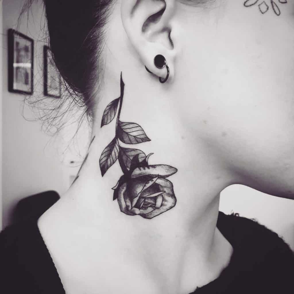 Black rose tattoo on woman's neck
