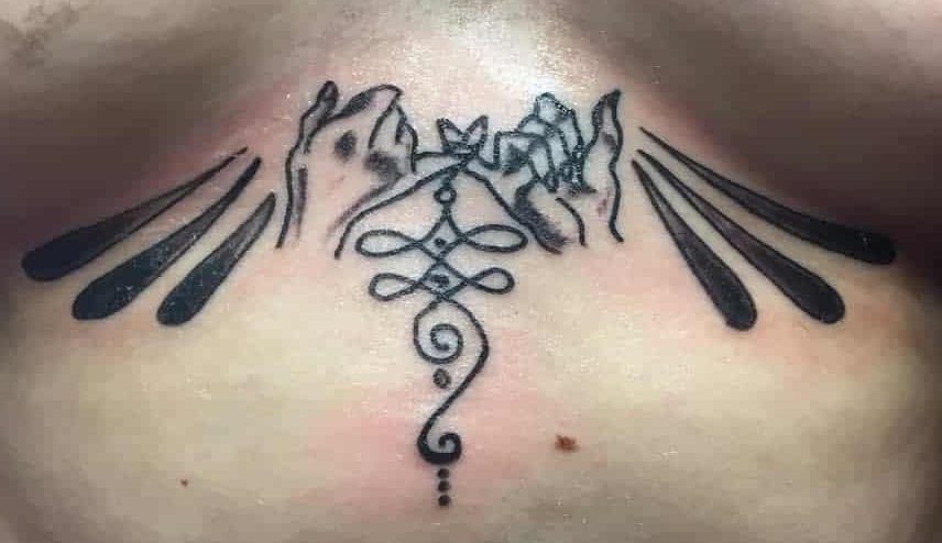 Stylized pinky promise tattoo on the sternum, featuring bold black ink designs, abstract lines, and intricate ornamental details