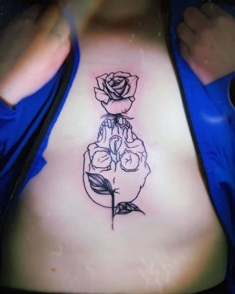 Minimalist black ink chest tattoo of an anatomical heart growing into a rose, symbolizing love, life, and transformation.