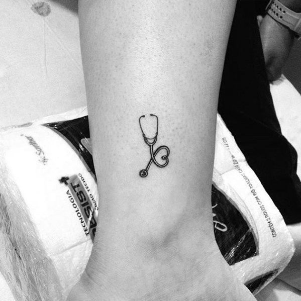 Small and delicate stethoscope tattoo on the ankle, with the tubing forming a heart shape, symbolizing love and dedication to the medical field.