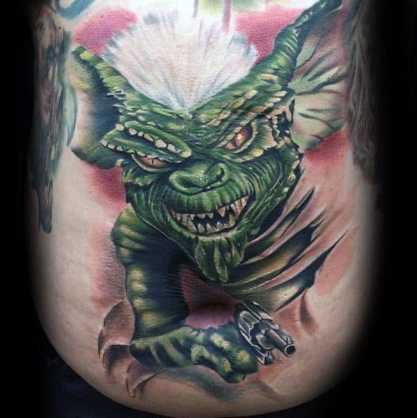 Realistic Gremlin tattoo with white hair, fierce red eyes, and a gun, bursting through the skin for a bold and intense design.