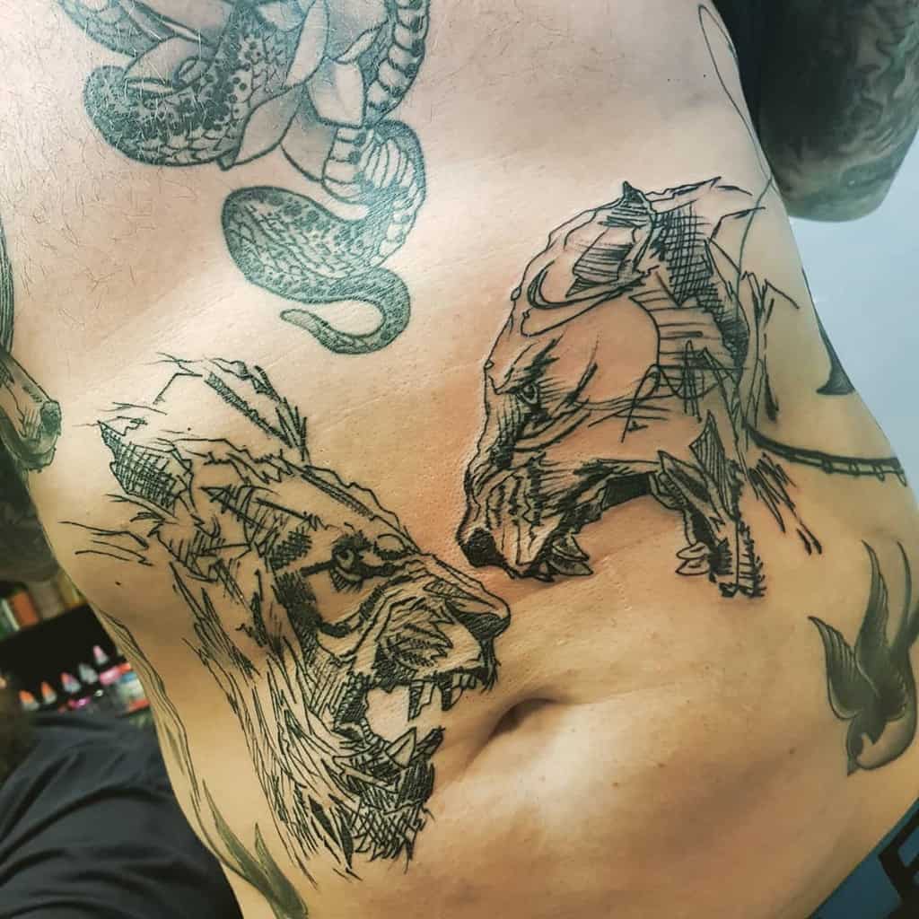 Bold sketch-style tattoo on the ribs, featuring a roaring lion and lioness facing off with aggressive linework for a raw, intense look.