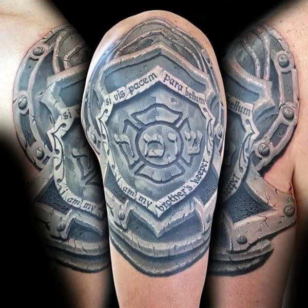 3D-style upper arm tattoo of a firefighter shield with the Maltese cross, wrapped in a banner reading "si vis pacem para bellum" and "I am my brother's keeper."