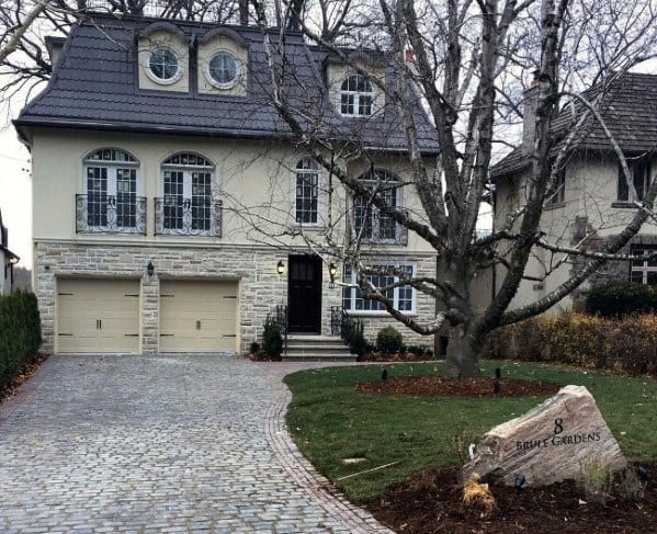 Cobblestone driveway with a natural, timeless appearance leading to a classic-style home.