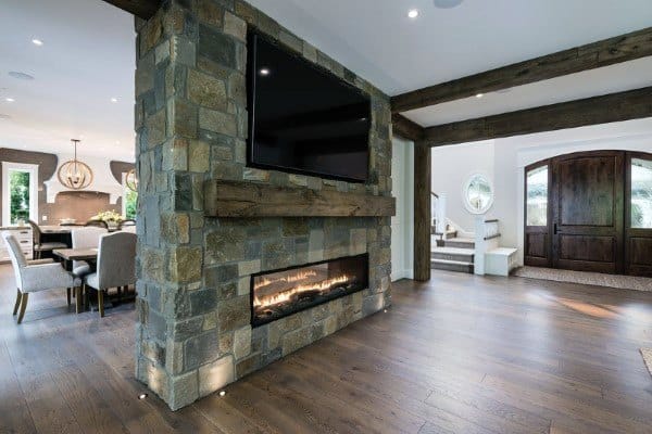 Modern stone fireplace with a wooden mantel and built-in TV for a sleek, functional look.