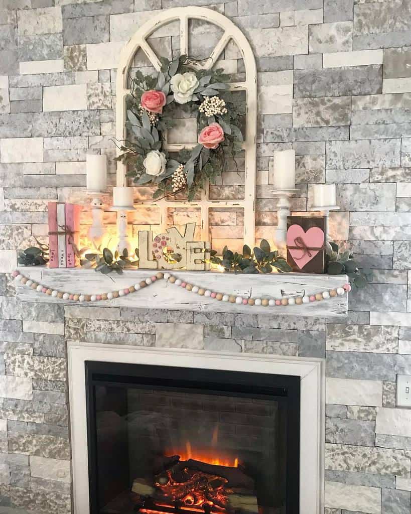 stone fireplace wood mantle floral wreath candles love sign