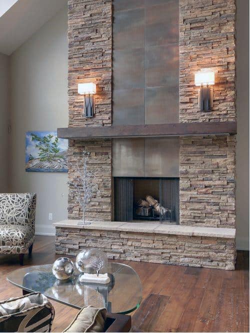 Modern stacked stone fireplace with metal accents and warm lighting.