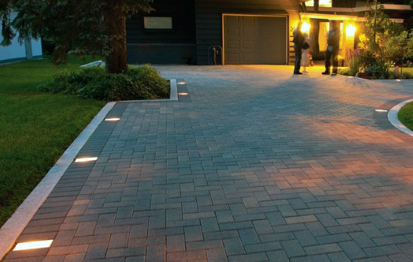 Driveway with embedded stone paver lighting, casting soft illumination along the path and creating a welcoming, luxurious ambiance at night