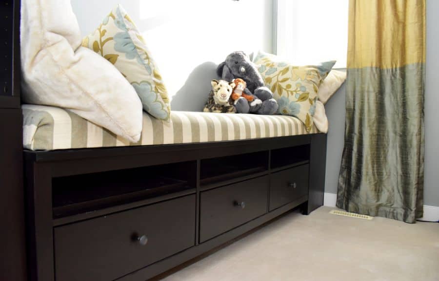 Built-in seating with striped cushions, floral pillows, and storage drawers underneath.