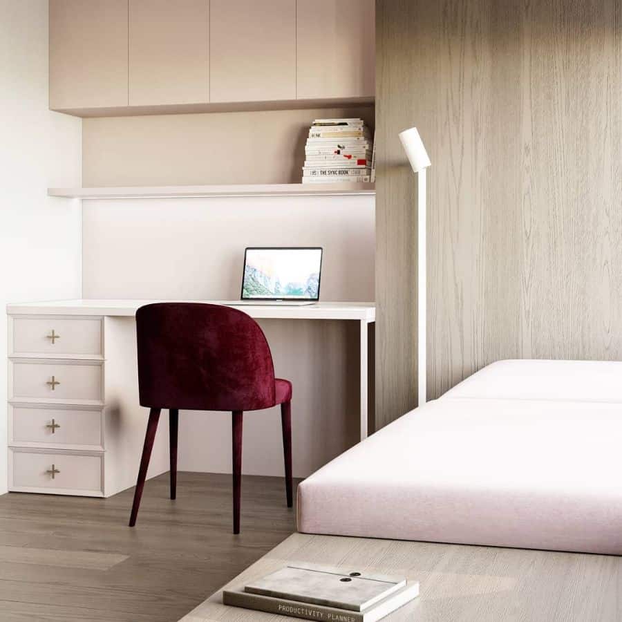 Minimalist bedroom workspace with white desk, red chair, and built-in shelving.