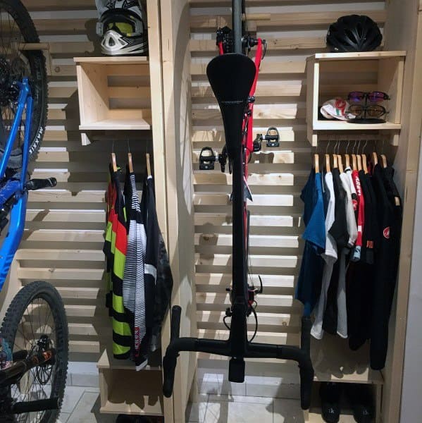 Organized bike garage with vertical racks, shelves for helmets, and hanging space for cycling gear.