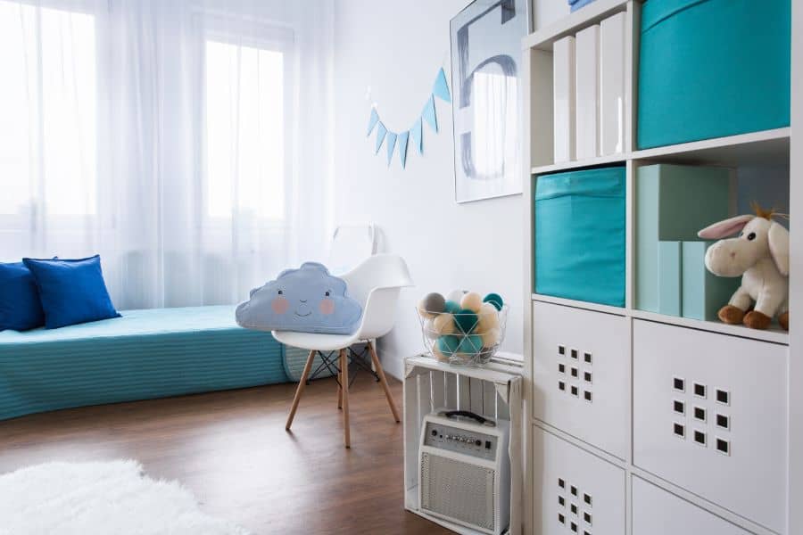 kids playroom with white cabinet storage and small bed