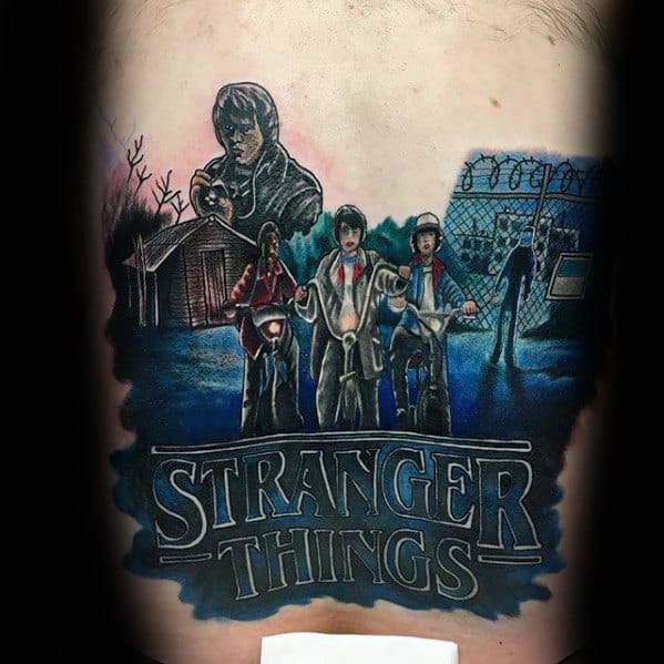 Detailed Stranger Things tattoo featuring main characters on bikes, Joyce with Christmas lights, a lab scene, and the show’s logo below.