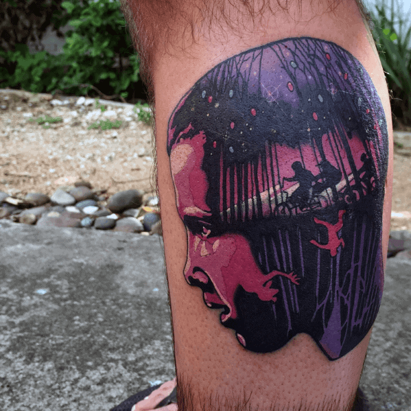 Bold Stranger Things tattoo of Eleven’s profile in purple tones, with silhouettes of kids biking and a figure falling into the Upside Down inside.