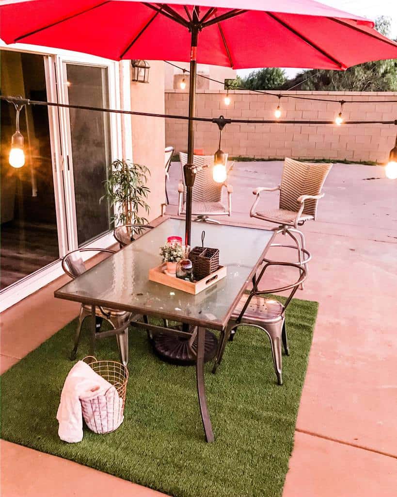 simple backyard patio with fake grass and large umbrella