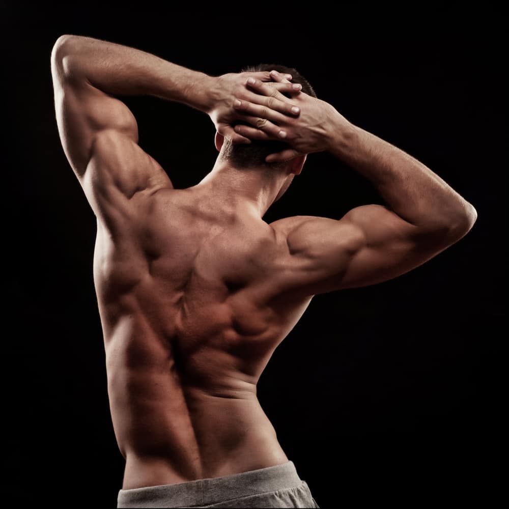 strong young athletic mans back isolated on black background