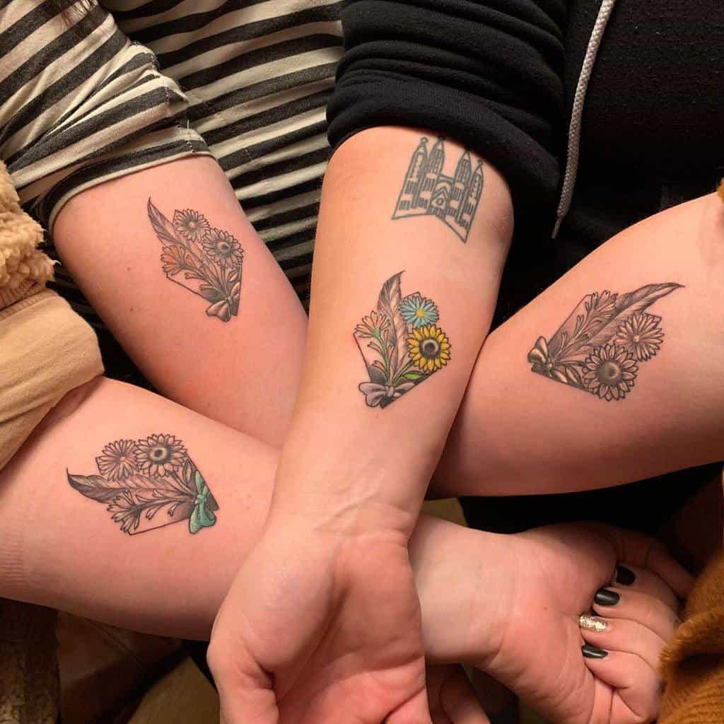 Matching sister tattoos featuring floral arrangements with delicate leaves and daisies, each with unique color variations