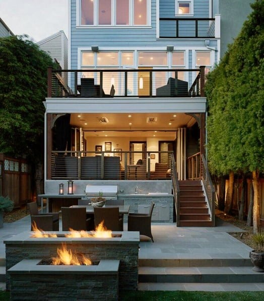 Modern multi-story home with outdoor patio, built-in grill, fire pit, dining area, and large windows