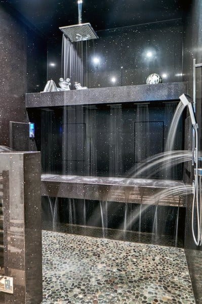 Luxurious shower with a black stone backdrop, multiple showerheads delivering a unique water flow, and soft lighting for a spa-like experience