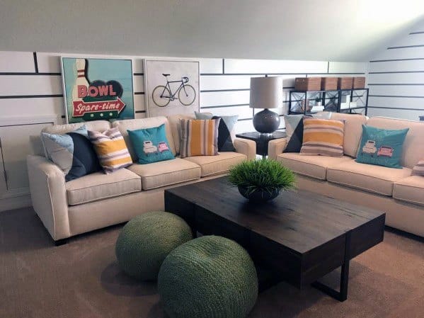 Stylish lounge with cream sofas, colorful pillows, wooden coffee table, and decorative wall art.