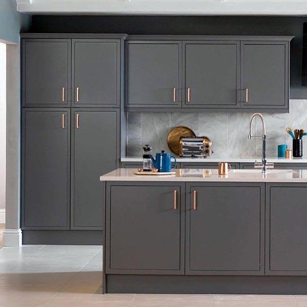 Modern grey kitchen with sleek cabinetry, a glossy countertop, and copper hardware for a stylish finish.