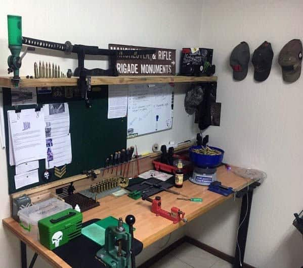 Compact and functional reloading bench setup with dedicated storage for tools, reloading presses, bullet trays, and unique wall-mounted displays, featuring an organized and personalized workspace