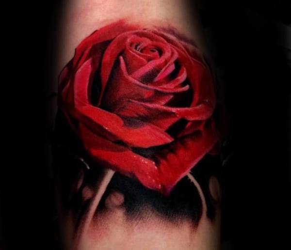 Tattoo of a red rose with detailed petals and shadowing on skin
