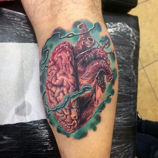 Colorful tattoo merging a human brain and heart into one form, surrounded by teal-green smoke and electric veins, symbolizing mind and emotion.