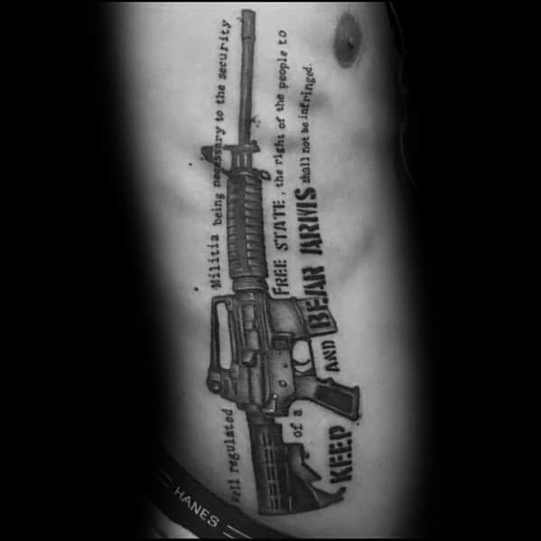 Black and grey AR-15 tattoo on the ribcage, featuring stylized Second Amendment text, symbolizing gun rights, freedom, and constitutional protection.