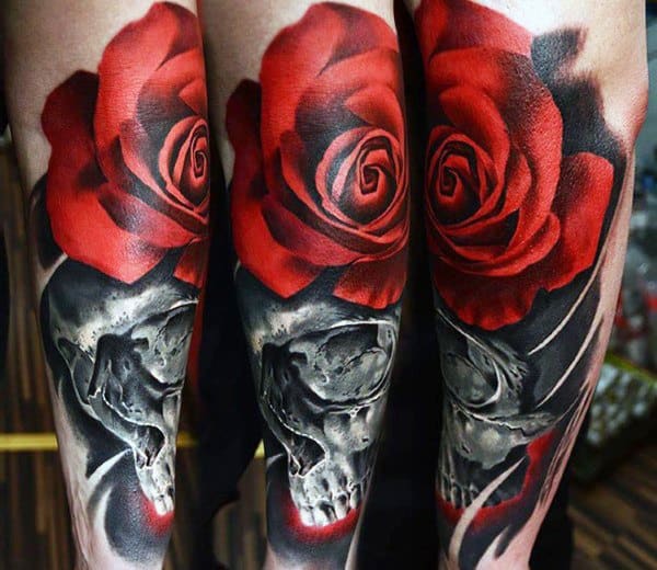 Bold tattoo of a realistic skull with vibrant red roses, featuring high contrast shading and deep black tones for a striking forearm design.