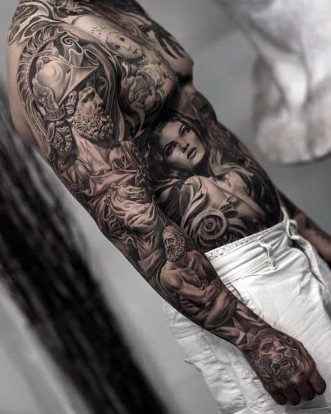 Black and grey full-body tattoo featuring a warrior in a helmet, a detailed female portrait, skulls, and intricate shading for a dramatic and artistic design.