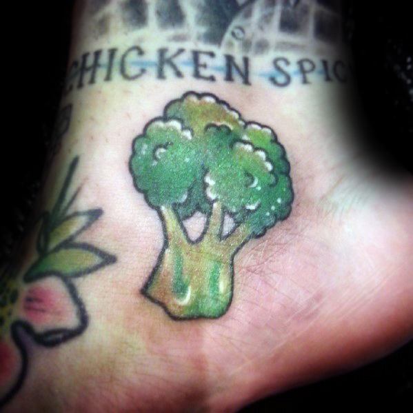 Small broccoli tattoo on the foot, featuring bright green shading and bold outlines for a playful and eye-catching design.