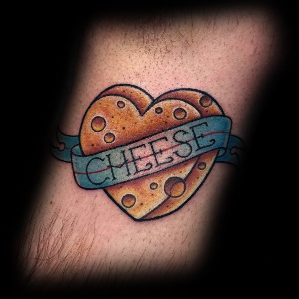 Colorful tattoo of a heart-shaped wedge of cheese wrapped in a blue ribbon that reads "CHEESE," featuring bold outlines and rich shading for a classic look.