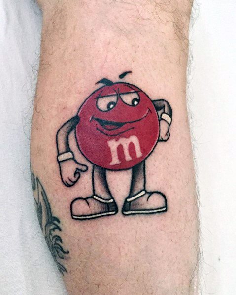 Colorful tattoo of the red M&M character with a confident expression, featuring bold outlines and shading for a vibrant cartoon-like effect.