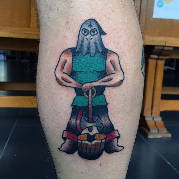 Neo-traditional executioner tattoo featuring a muscular hooded figure in a green tunic, gripping an axe over a severed head on a block.