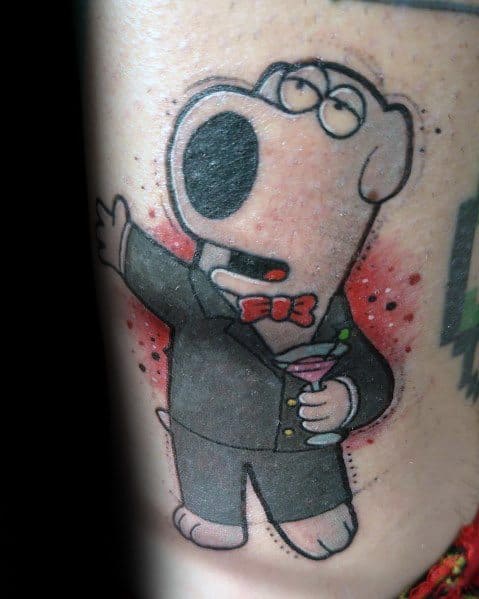 Tattoo of Brian Griffin from Family Guy dressed in a tuxedo with a red bow tie, holding a martini, singing dramatically against a red-speckled background.